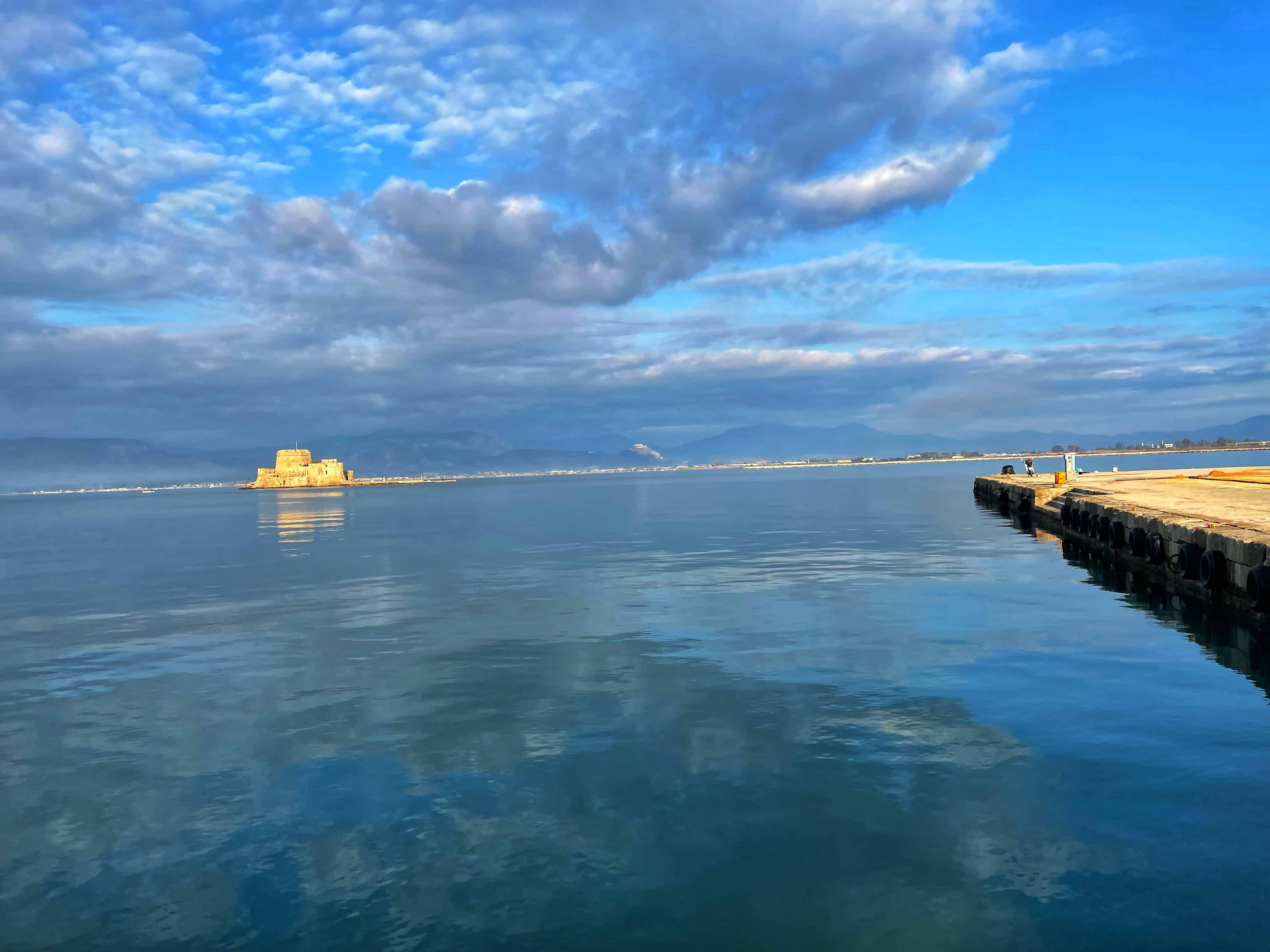 The Bourtzi fortress reflected in still water at dawn, Nafplio, Greece